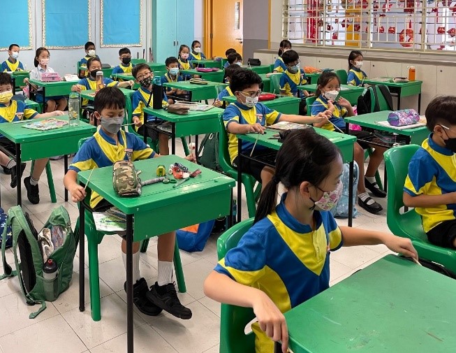 P3 pupils playing an imaginary Korean janggu using chopsticks and a table